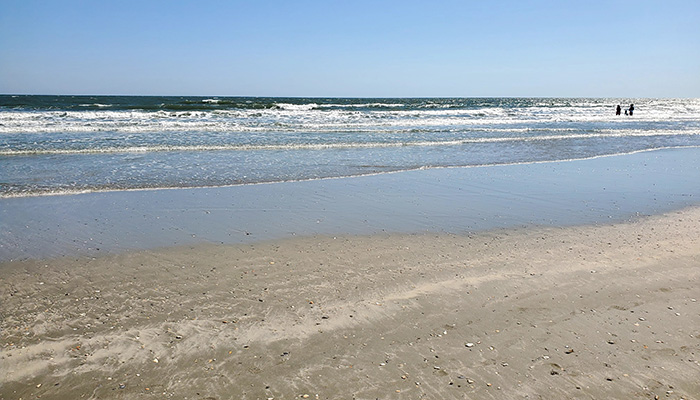a view of the beach at North Myrtle beach. The foreground is sand. The waves are lapping the shore.
